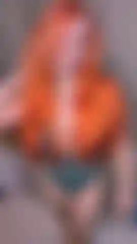 La pelirroja traviesa se inclina sobre su escritorio para ti.