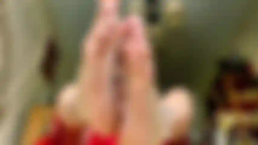 Streaming vestido rojo astillado uñas blancas.