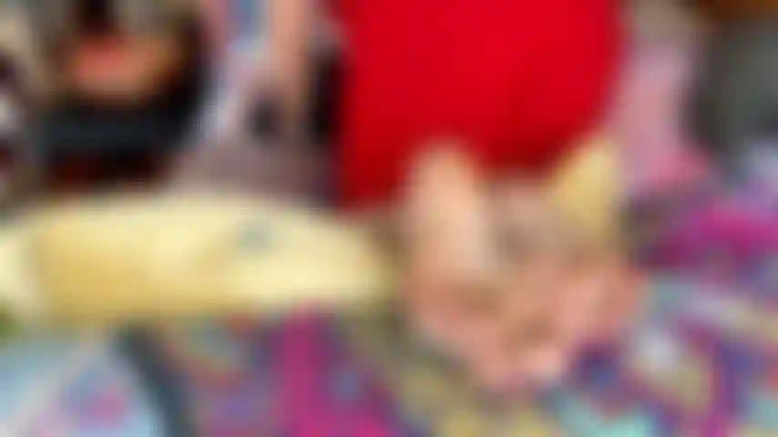 Vestido rojo ajustado, las suelas del sofá muestran morados.