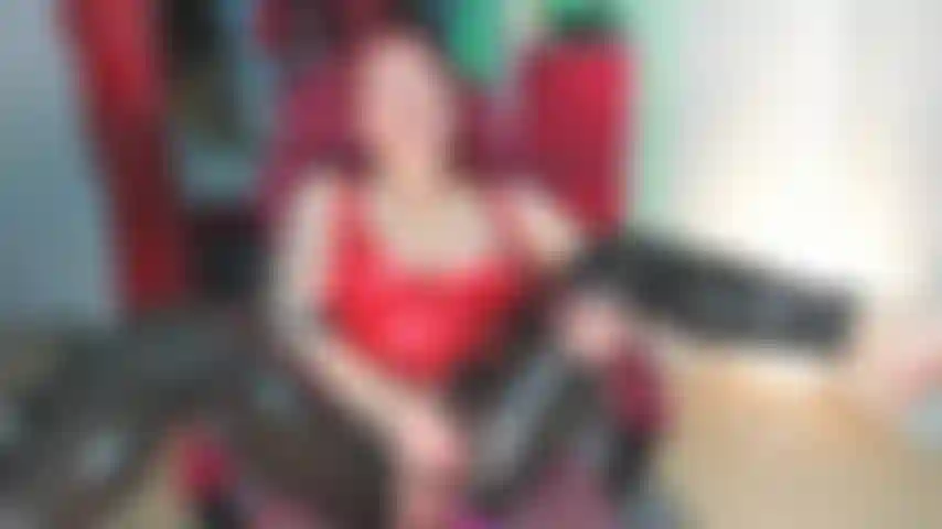 Squirt enorme con calzas de látex negras y top de látex rojo.