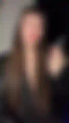 Diosa emily fumando en cuero y encaje con labios rojos.