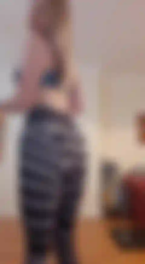 En cuclillas y exhibiendo ropa de gimnasia.