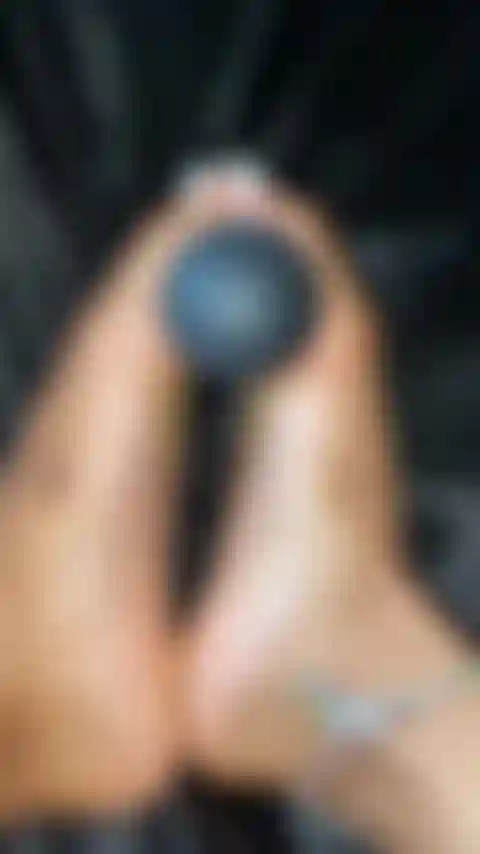 Los dedos de los pies bastante blancos juegan con el juguete.