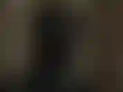 Una amante pervertida con capucha de látex que se burla de tu polla y tus pezones mientras usa una máscara de látex negra brillante.