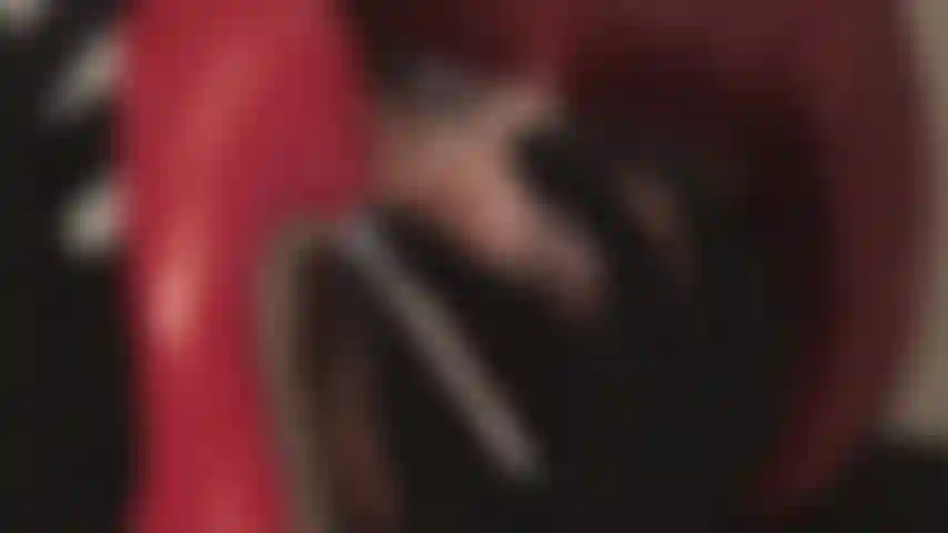 Lamiendo tacones rojos y brillantes.