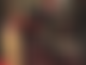 Traje de látex negro ajustado y guantes rojos.