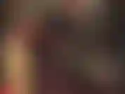 Traje de látex negro ajustado y guantes rojos.