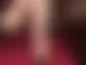 Mulas de cuero negro con los pies descalzos colgando.