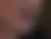 Primer plano de la cara, lápiz labial y lengua se burlan mientras la amante se burla con guantes de látex rojo brillante.