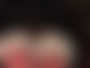 Primer plano de medias de nailon con encaje blanco sobre látex rojo. Tu diosa del látex se burla con la vista puesta en sus sexys bragas de látex brillante.