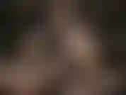 Diosa de cuero con gafas sexys, acaricia su enorme strap-on blanco.