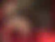 Vista lateral de piernas sexys en medias con costura y ligas con tacones colgantes.