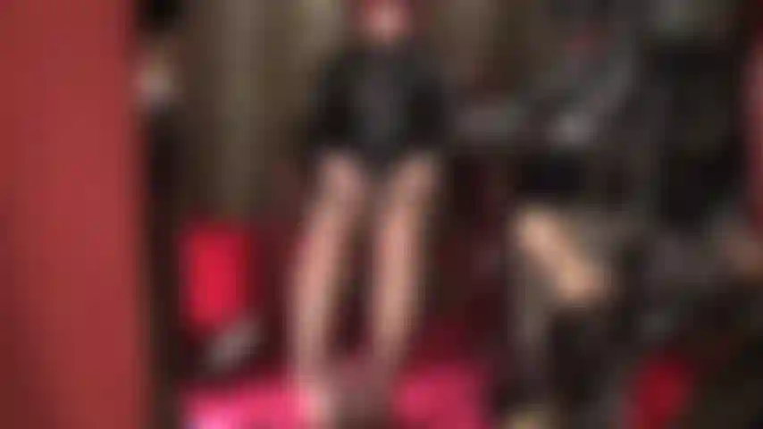 Ama acaricia dos pollas - vestida con pvc brillante y medias marrones, sus pies están envueltos alrededor de una polla negra mientras la ama acaricia su strap-on blanco con las manos desnudas.