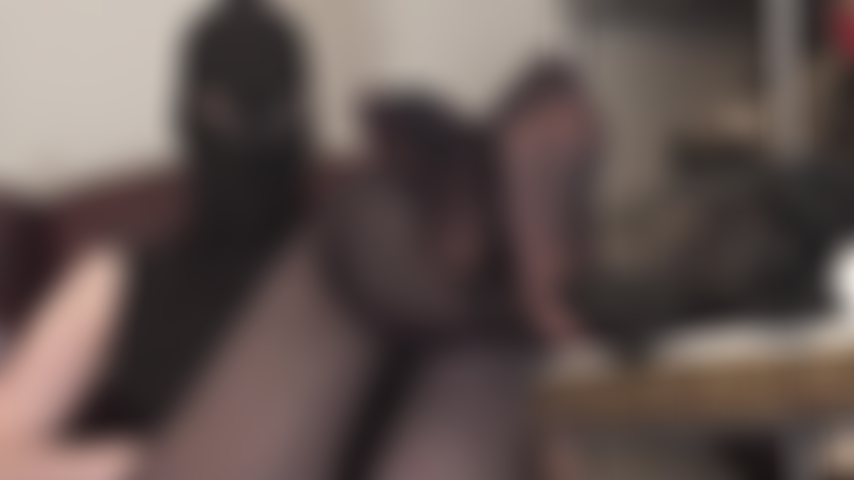 Fetichista de capucha con ojos abiertos de lycra y adoración de pies en pantimedias y zapatos de tacón de aguja con suela roja.