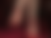 Fetichista de pies descalzos, con tacones de aguja y tiras rojas en el tobillo, colgando.