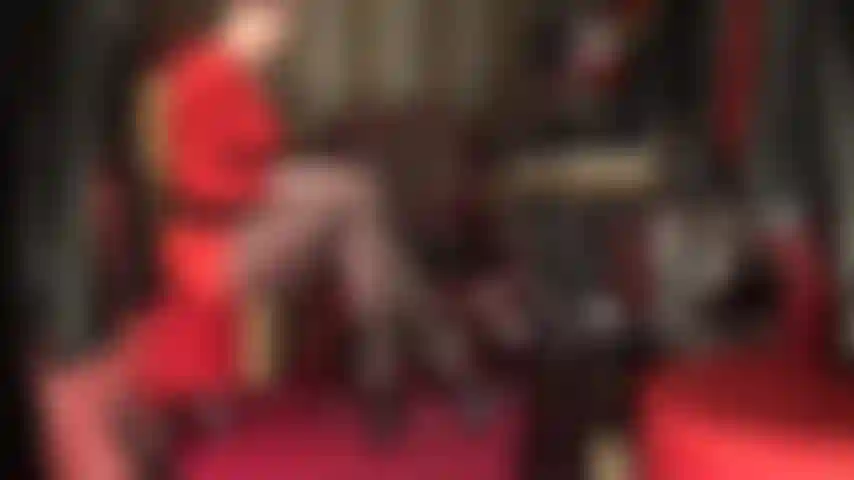 Estas piernas largas son tu debilidad - la diosa se burla con una vista lateral de sus increíbles piernas de nailon cruzadas en medias negras transparentes con tacones altos de tiras y plataforma alta.