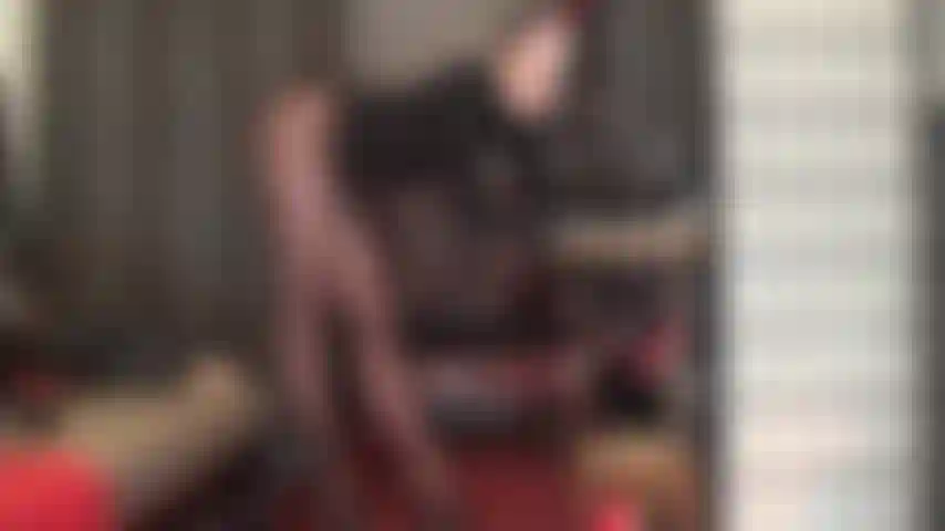 Provocando las piernas de las medias y los pies de la amante en medias marrones opacas y mules de tacón alto de cuero negro.