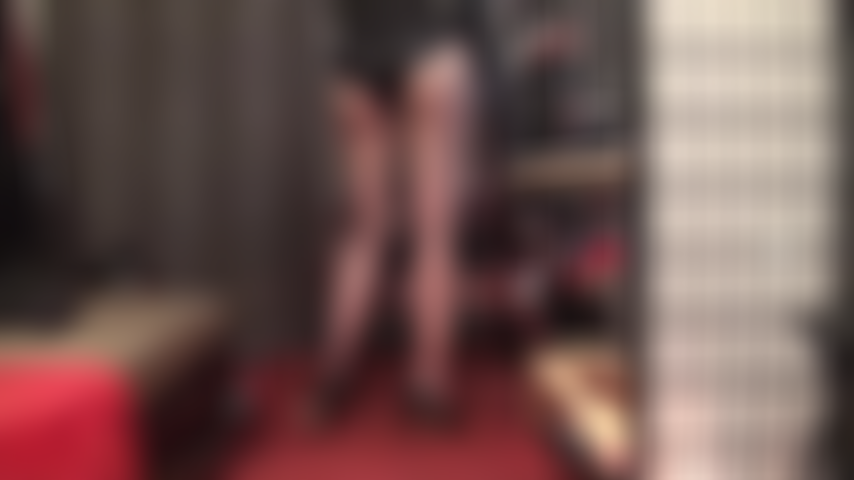 Adoración al cuerpo en un traje brillante con efecto mojado, glúteos provocados por medias negras transparentes.