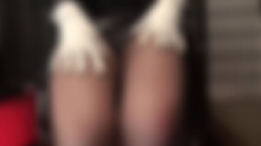 Provocación en blanco y negro: bonitos tacones blancos con tiras en el tobillo, guantes blancos y un body blanco contrastan con el brillante pvc negro. Amante provoca con vistas bajo la falda y piernas en medias color café.