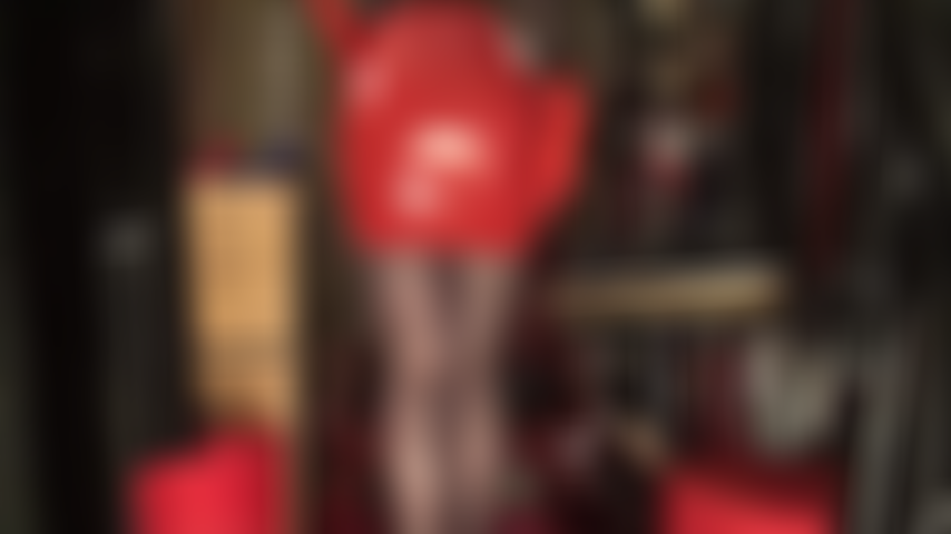 Falda sexy de látex rojo, guantes de goma, medias negras y tacones rojos.