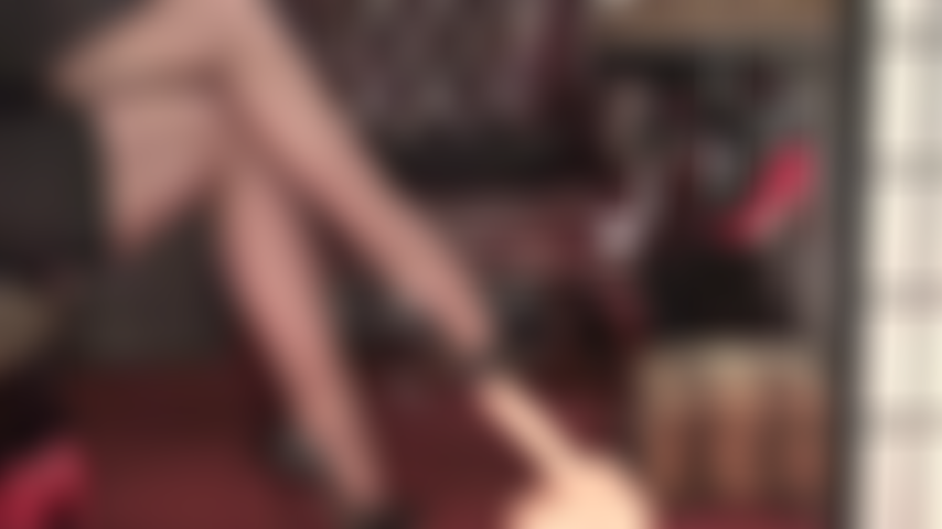 Piernas con medias brillantes de color marrón oscuro, tacones altos y pies que tienen tu polla bajo control total.