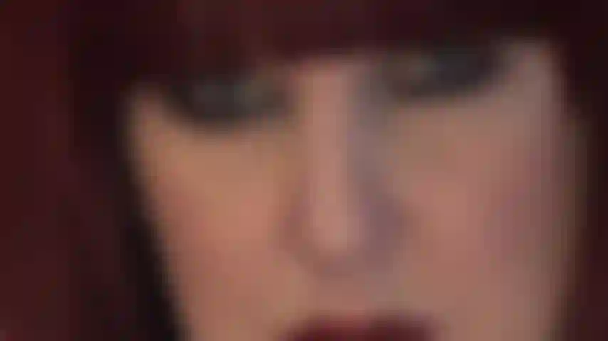 El rostro hipnótico de la ama: deliciosos labios rojos y penetrantes ojos azules que miran directamente a tu alma.