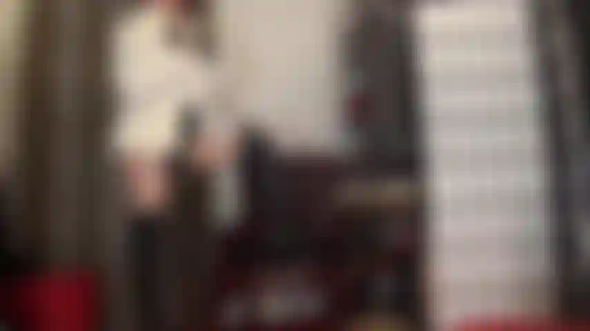 Amante de strapon en cuero negro, medias brillantes y abrigo de piel blanco: diosa del cuero y la piel que se masturba su gran polla negra sosteniendo un bolígrafo como un cigarrillo y provocando con su hermosa falda de cuero y botas largas.