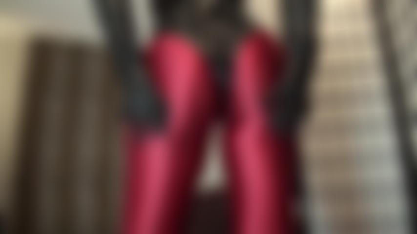 Medias de spandex rojas brillantes y tanga de pvc ajustado - oh, tener ese fabuloso culo redondo bajado sobre tu cara, aunque sea solo para olerlo... Mistress toca y aprieta su trasero perfecto con guantes de cuero - tan cerca de ti.
