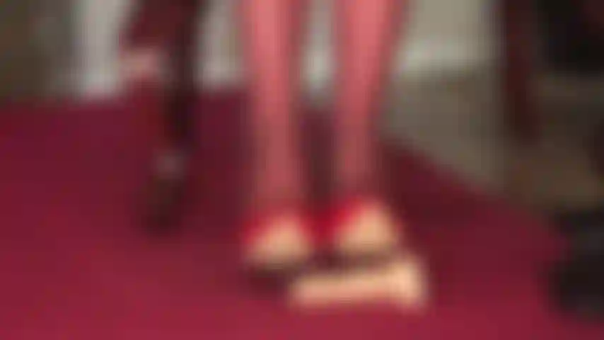 Tacones de charol rojo brillante, pies en pantimedias y fusta para atormentar tu polla de esclava.