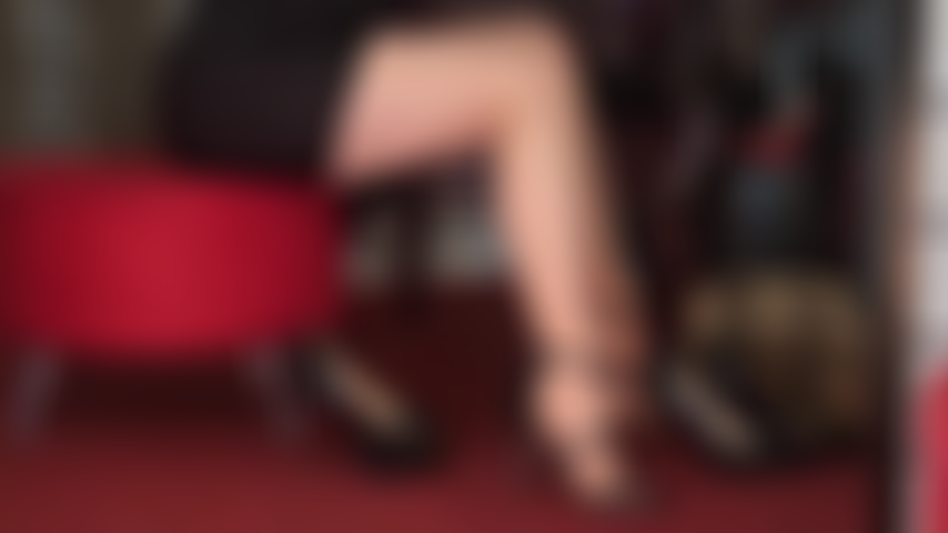 Seduciendo piernas y pies en medias bronceadas y varios pares de tacones altos negros sexys.