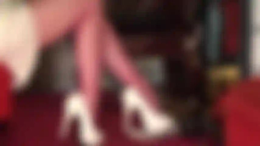 Hermosos muslos y piernas en pantimedias rojas con vistas hasta la falda en bonita falda de satén.