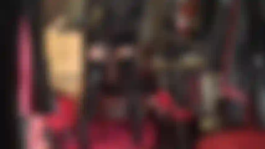 Body de pvc y nailon en pose sentada, botas altas, medias brillantes, falda de pvc y body de nailon transparente debajo.