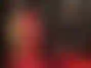 Una amante vestida de látex rojo y negro. La falda se acorta, luego cambia a una minifalda negra, seguida de medias blancas de encaje de nailon sobre látex. ¡Qué sexy!