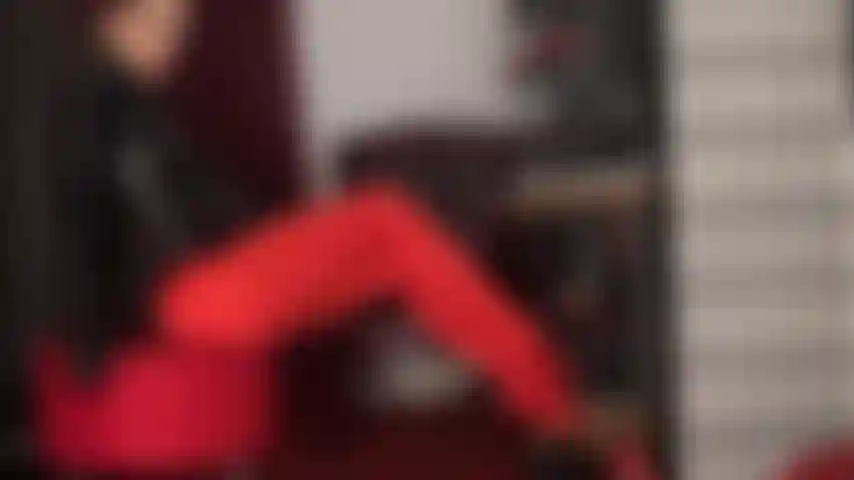 Piernas y escote: piernas lentas y sensuales se burlan en medias de lycra rojo brillante y una seductora cremallera en el body de la amante.