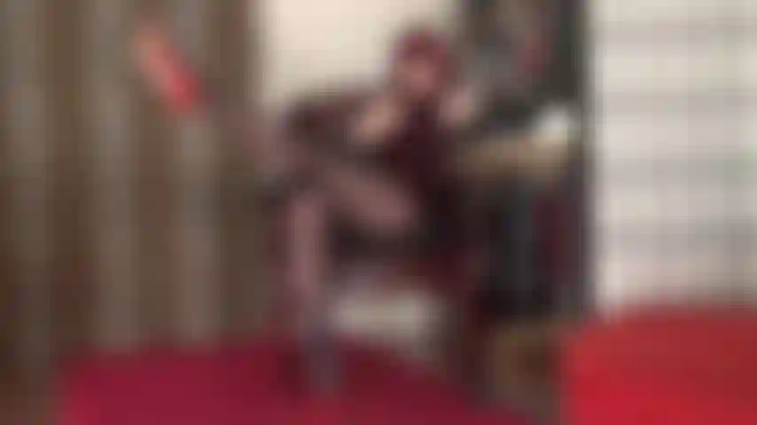 Piernas largas en pantimedias extendidas, juego con zapatos y tacones rojos colgantes, fetiche de pies.