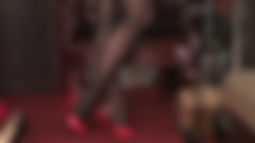 Medias negras brillantes con acabado aceitado y mules rojos de tacón alto.