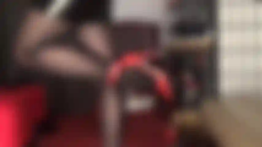 Disfruto de esta provocación de piernas con medias negras brillantes y zapatos de tacón de cuero rojo con tiras en el tobillo.