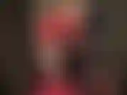 Señora vivian, vestida de látex rojo brillante, piernas desnudas, tacones altos, guantes largos y brillantes.