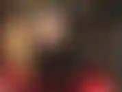 Una vista debajo de la sexy falda de vinilo de corte ancho y negro de la amante revela medias negras transparentes y botas altas y brillantes.