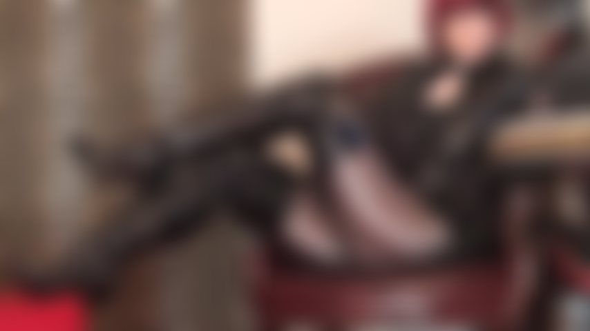 Diosa fetichista súper caliente en pvc negro brillante, botas largas hasta la rodilla y medias de spandex marrón metálico brillante.