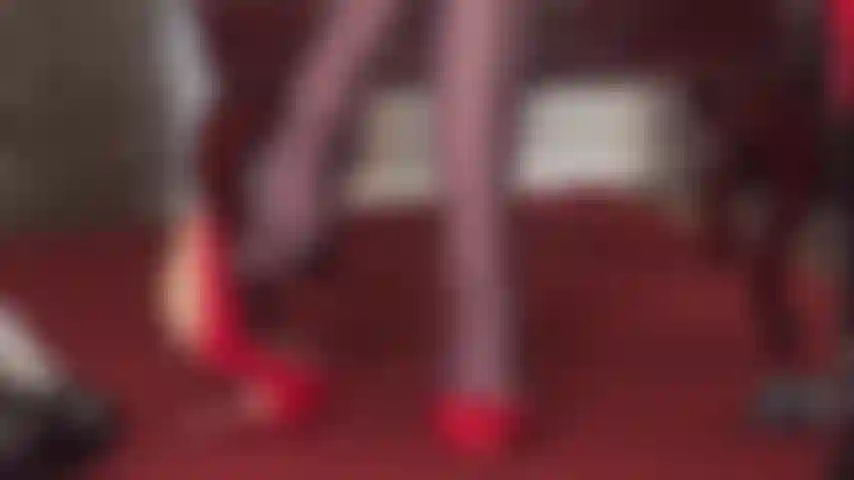 La señora vivian muestra sus habilidades colgantes con un par de tacones rojos brillantes y medias brillantes de color marrón oscuro, con una fusta en la mano.