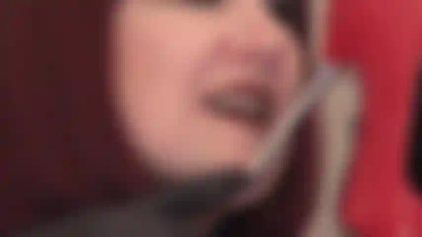 Guantes de cuero negro, labios y lengua pintados sobre tacones de aguja de metal brillante.