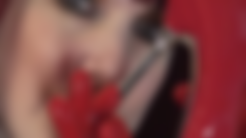 Guantes fetichistas de látex rojo pervertidos sobre tacones de acero rojo patentados y polla negra provocativa.