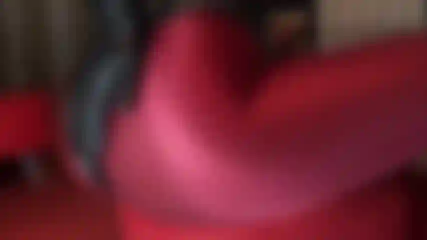 Ama muestra sus magníficas curvas en este atuendo fetichista caliente de pantimedias de lycra rojo burdeos, body de pvc, botas de aguja y guantes de cuero.