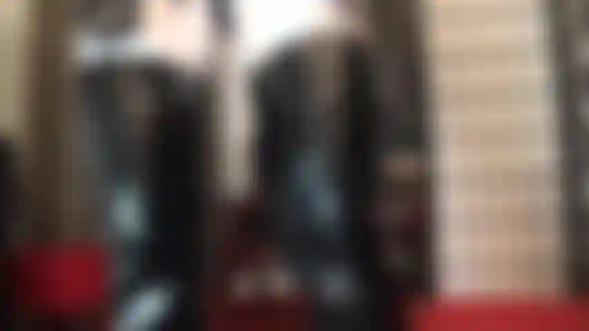 Traje blanco y negro de botas y guantes fetichistas de pvc brillante combinados con medias de lycra blancas brillantes.