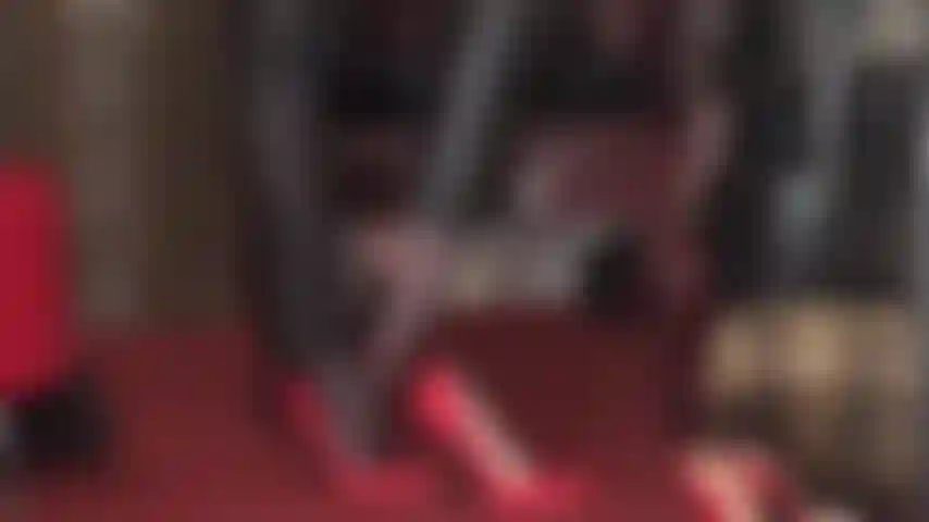 Fetichista de pies y adoración de tacones altos: pantalones de cuero y tacones de aguja rojos y medias de red para provocar los pies.