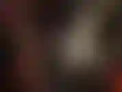 Hermosa amante del pvc con abrigo largo de vinilo brillante, guantes y botas hasta el muslo.