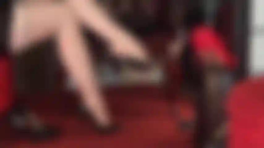 Medias con liga estampadas y costuras color nude, piernas cruzadas y pies seductores que cuelgan diferentes pares de tacones clásicos.