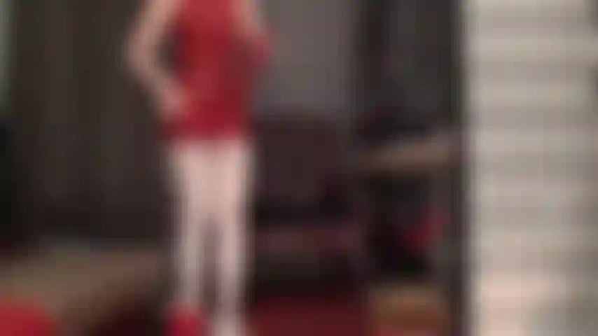 El látex rojo combina a la perfección con medias blancas. La ama lleva un minivestido rojo de goma y medias blancas brillantes. Se pone guantes de látex hasta los hombros y una diminuta tanga roja para tentar a las vistas bajo la falda.