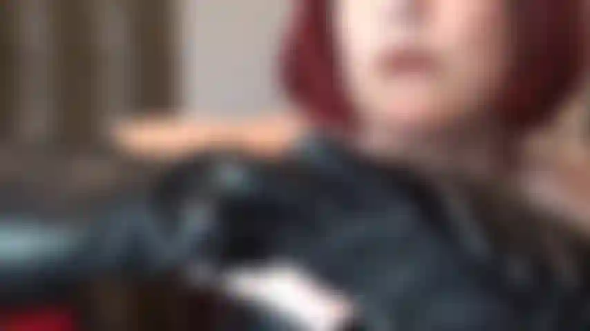 Una hermosa tentación de cuero: cuero negro sobre piel blanca pálida. La señora vivian provoca con hombros descubiertos, corsé de cuero y guantes hasta los hombros.